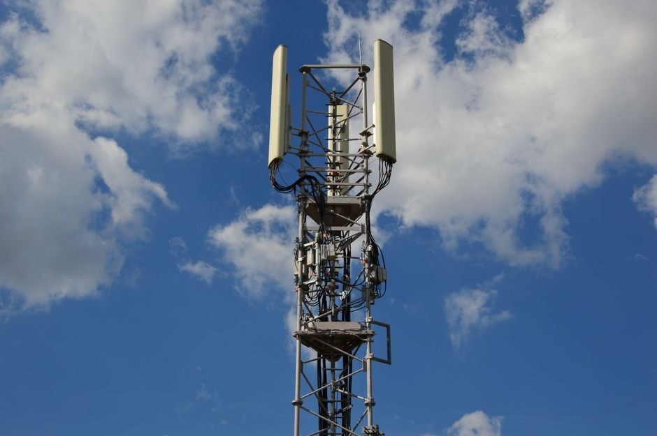 5G cell tower and antenna array against a city skyline