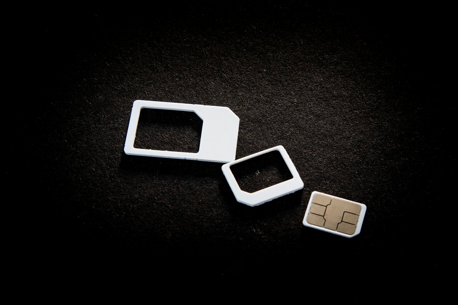 eSIM vs physical SIM: physical SIM cards and adapters laid out on a table